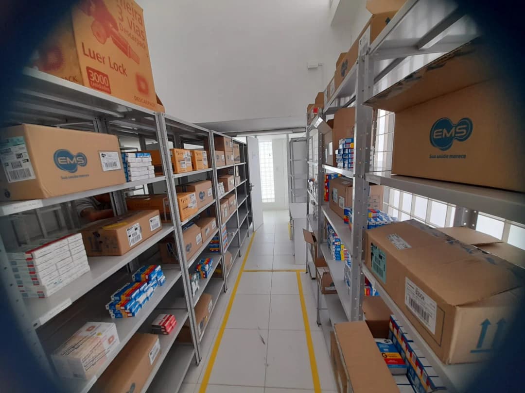 Área de estoque da Jasmed, com prateleiras organizadas de produtos para saúde