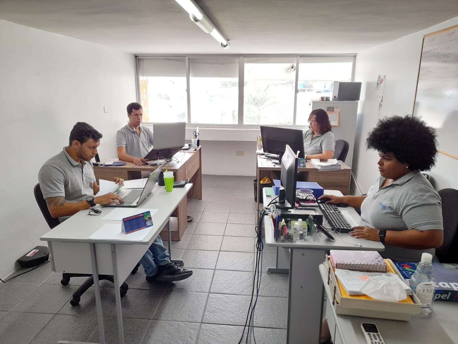Equipe administrativa e comercial da Jasmed trabalhando no escritório em Jaboatão dos Guararapes
